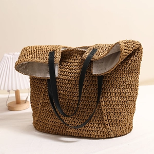 Braune handgewebte Strohtasche mit schwarzen Ledergriffen für den Strandurlaub