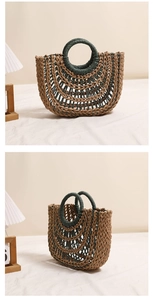 Close-up of handmade hollow straw handbag with round handles and bicolor weave details