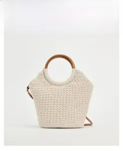 Detail view of cream cotton woven tote bag featuring round wooden handles for summer holidays