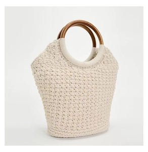 Detailed texture of cotton rope weave with circular dark wooden handle on tote bag