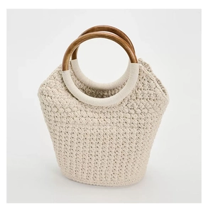 Close-up of cream cotton woven tote featuring a dark brown round wooden handle