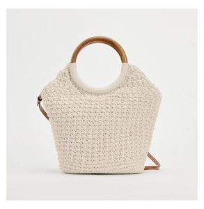 Close-up of woven cotton tote featuring round wooden handles and a brown leather strap