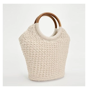 Detailed macro view of beige woven cotton texture with brown round wooden handles