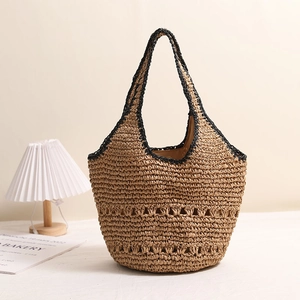 Large woven straw tote bag with black trim and hollowed details for beach vacation