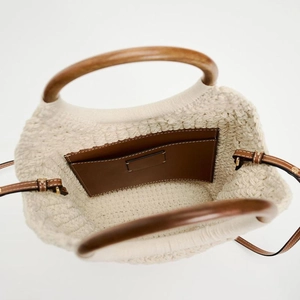 Large cotton woven tote bag with round wood handles and leather strap on white background