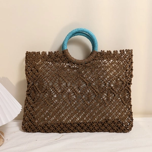 Square brown straw tote bag with cutout pattern and light blue round handles