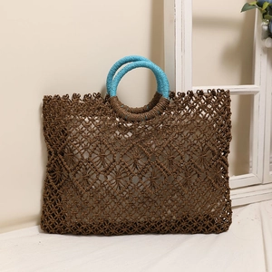 Square dark brown woven straw bag with contrasting blue round handles for summer beach