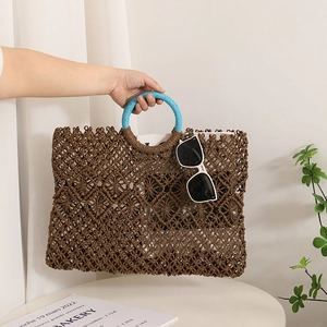 Square woven straw tote bag with round handles and blue trim for beach vacations