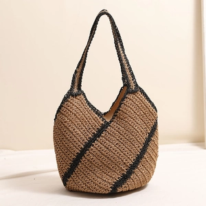 Handwoven straw tote bag with black geometric lines for beach vacation and summer style