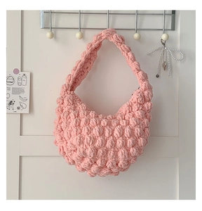 Close-up of pink popcorn stitch handmade knit handbag with 3D bubble textured detail