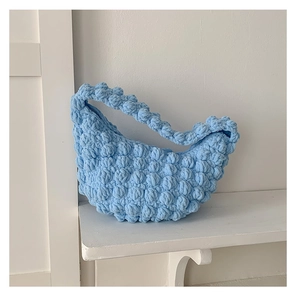 Close-up of handmade sky blue crochet handbag showing thick bubble texture and weave
