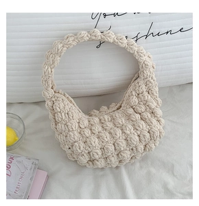 Detail of handmade cream woven bag showing 3D popcorn texture and minimalist crochet design