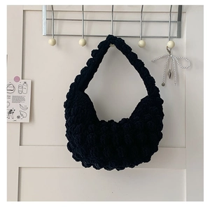 Detailed view of handmade black popcorn knit texture and thick cotton shoulder bag