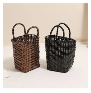 Detail of hand-woven basket bags in brown and black with durable dual handle design