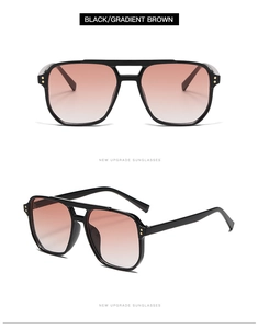 Détails de lunettes aviateur noires avec rivets dorés et verres dégradés marron