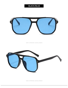 Détail des lunettes pilote avec verres bleus, rivets dorés et double pont noir élégant