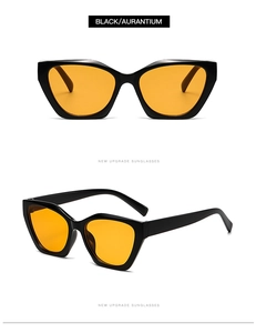 Detail view of cat eye sunglasses with black frames and transparent orange lenses
