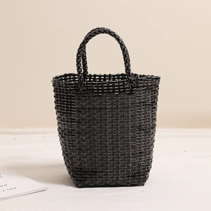 Minimalist black woven tote basket bag with circular handles for beach or casual outings