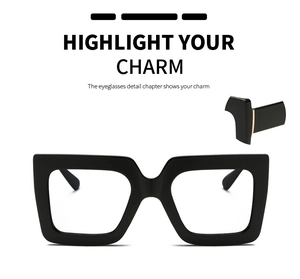 Detail of square black frame glasses with gold metal hinges and oversized designer lenses