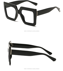 Detail of square black frame glasses featuring gold hardware accents on the temple hinge