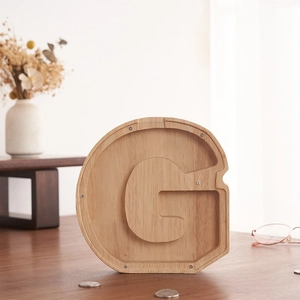 Detalle de hucha de madera en forma de G con panel transparente y vetas de madera clara