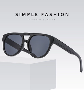 Detail of black double bridge sunglasses on a geometric stand with simple fashion text