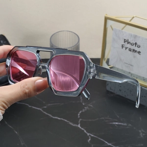 Detail of transparent grey double-bridge sunglasses with pink lenses in a lifestyle setting