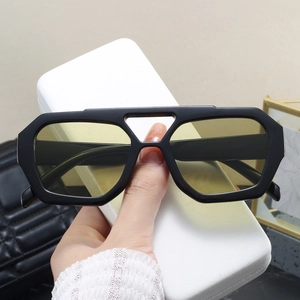 Detail of oversized retro sunglasses with double bridge and yellow transparent lenses