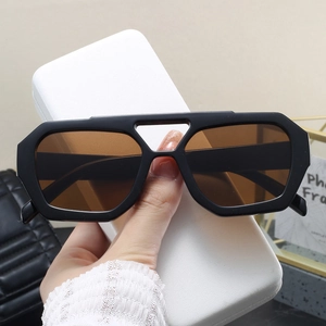 Detail of oversized double-bridge sunglasses with black frames and brown lenses