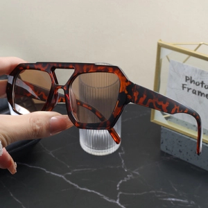 Close-up of retro double-bridge sunglasses with leopard tortoise frame and brown lenses