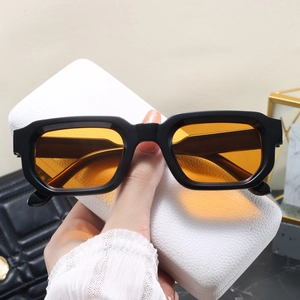 Détail de lunettes de soleil carrées vintage avec monture noire et verres orange