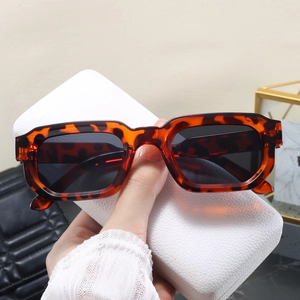 Gros plan de lunettes de soleil rectangulaires en écaille avec un étui de transport