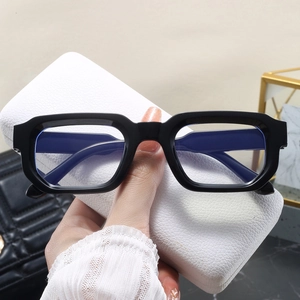Détail de lunettes carrées noires avec verres anti-lumière bleue et étui en cuir blanc