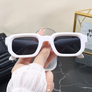 Vue rapprochée de lunettes de soleil rectangulaires blanches rétro avec des verres foncés