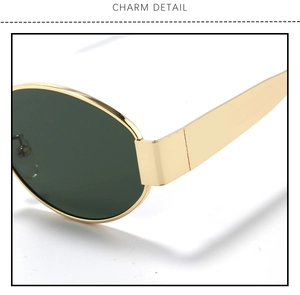 Macro detail of gold metal frame hinges and dark green oval lenses on sunglasses
