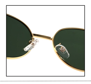 Detailed close-up of golden metal bridge and soft silicone nose pads on oval sunglasses