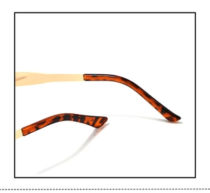 Detail of tortoiseshell temple tips and gold metal arms on small oval sunglasses