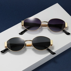 Modern oval metal sunglasses for women with gold frames and dark gradient lenses