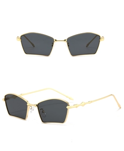 Close-up of golden geometric metal sunglasses with dark hexagonal lenses and wave temples