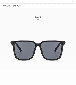 Detail of black square sunglasses with elegant gold rivets and dark lenses
