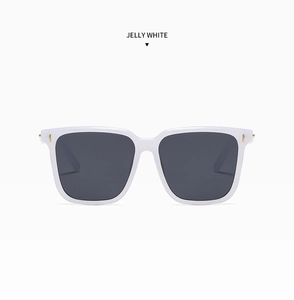 Detail of square jelly white sunglasses showing gold stripe studs and gray lenses