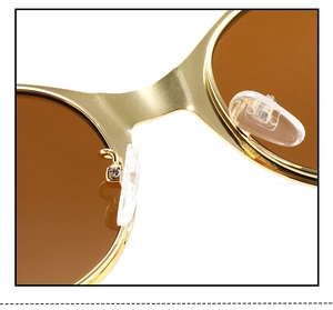 Macro view of gold metal frame sunglasses with brown lenses and silicone nose pads