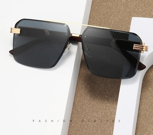 Detailed macro view of rimless rectangular sunglasses with dark lenses and gold bridge