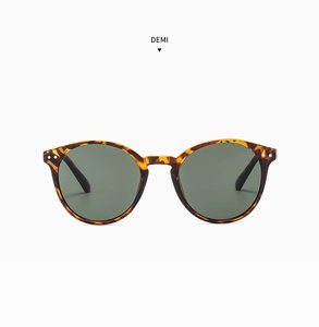 Détail de lunettes de soleil rondes léopard avec doubles rivets et verres verts