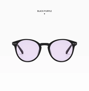 Détail de lunettes de soleil rondes noires avec verres violets et rivets en argent