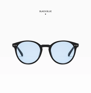 Détail de lunettes de soleil rondes noires avec verres bleus et rivets argentés