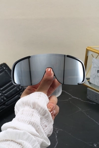 Close-up of silver mirrored oversized sports sunglasses with black semi-rimless frame