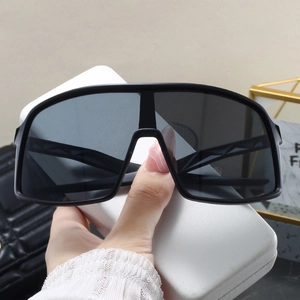 Macro shot of oversized black sports sunglasses with geometric temples and white hard case