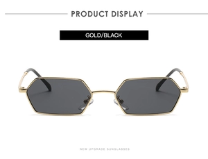 Detail of classic gold metal hexagonal sunglasses frame with sleek black lenses