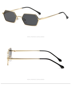 Detail of hexagonal metal sunglasses with gold frame and dark lenses on white background